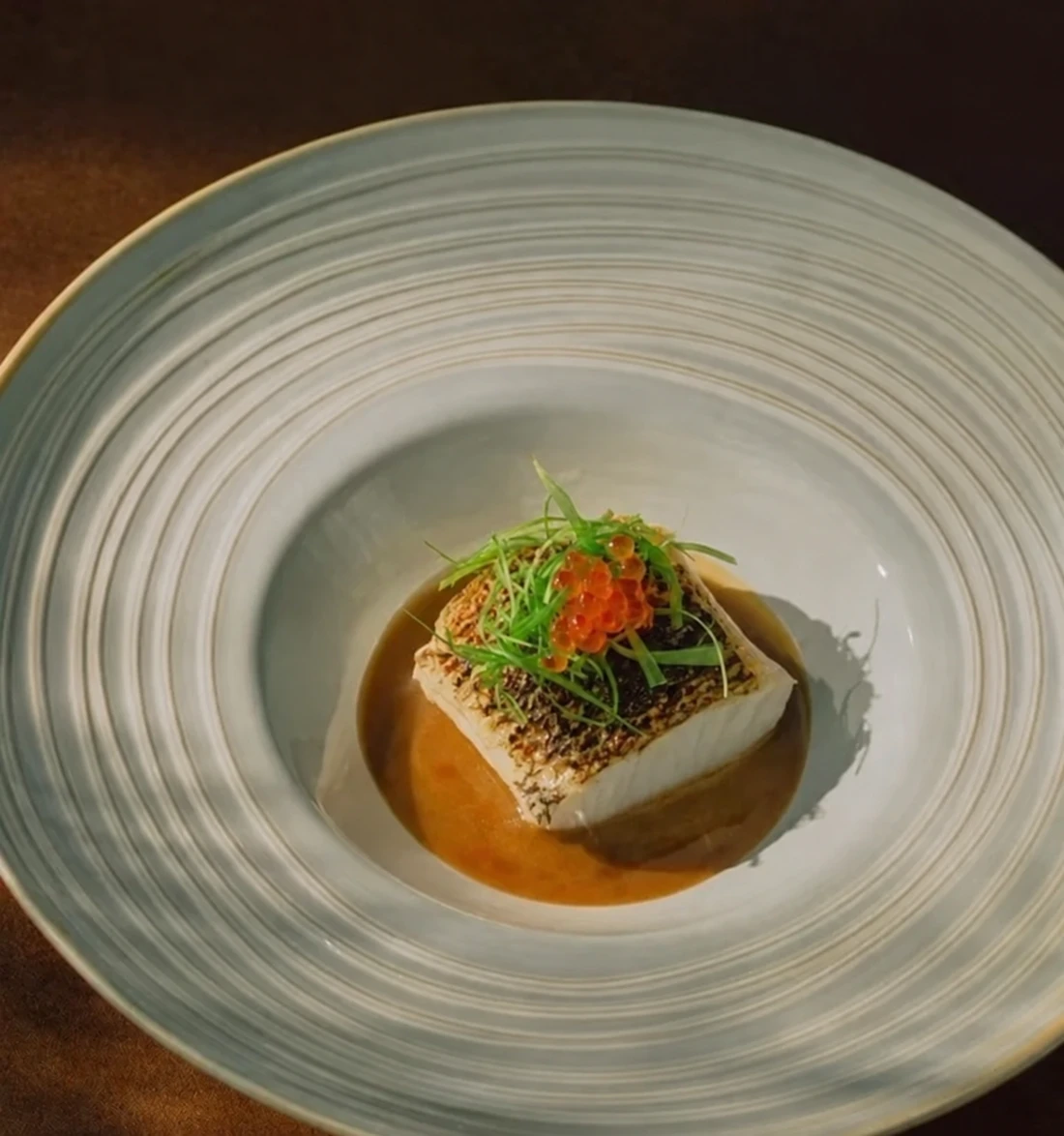 A plated dish with herbs and sauce